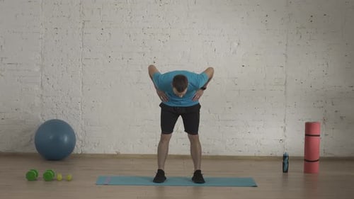 Man Fitness Coach in Sportswear Doing Upper Body Bends Warm Up for Online Class at the Home Studio