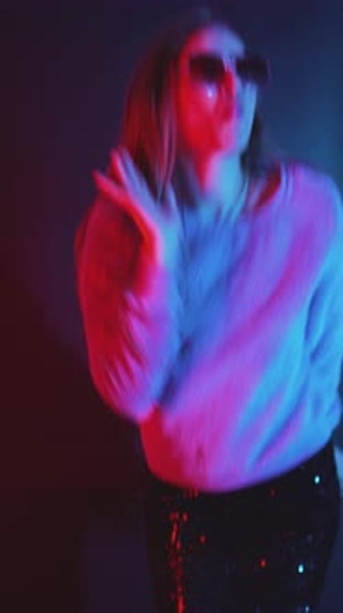 Stylish Woman Dancing Alone Under Colored Lights