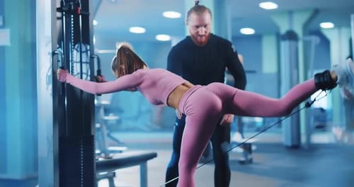 Caucasian Couple Fitness Trainer and Female Bodybuilder Using Gym Equipment Professional Performing