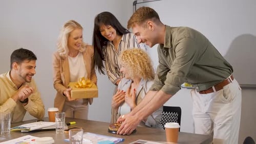 Group of business people celebrating birthday of their colleague at office.