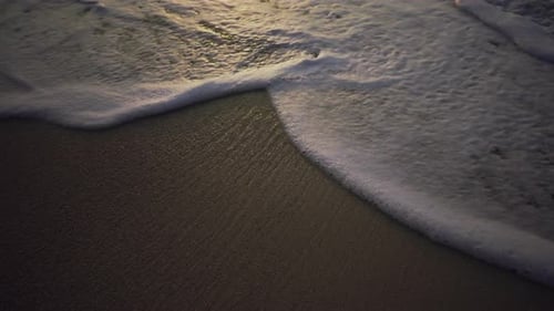 Close-up Shot of a Sandy Beach and Sea Waves Coming on Shore.