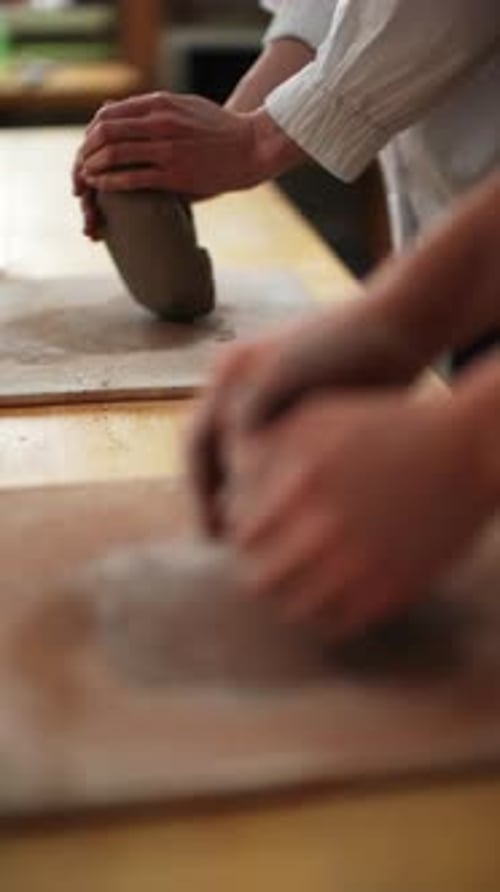 People Working with Clay in a Studio