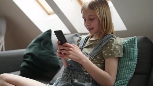 Teen Using Mobile Phone While Relaxing on Couch