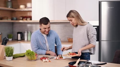 Smiling Couple Cooking Together in Modern Kitchen
