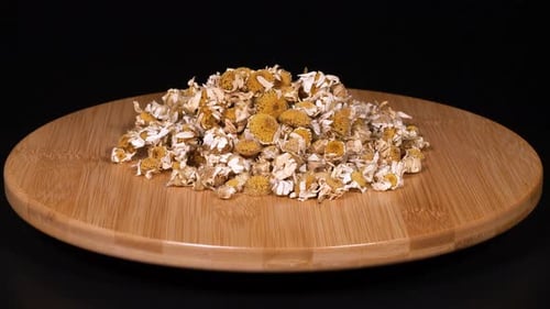 Dried Chamomile Flowers on a Wooden Plate