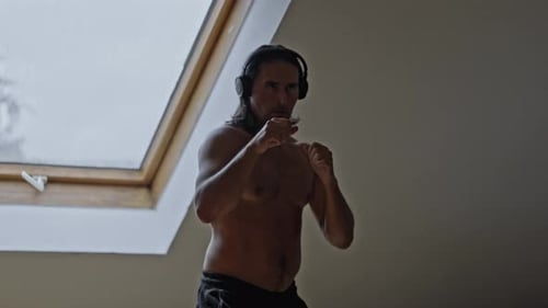 A Man Demonstrates His Boxing Skills A Dynamic Fitness Pose Beautifully Captured Under a Skylight