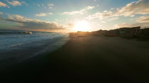 Sunset Beach With Waves and Buildings
