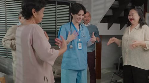 Healthcare Worker Leading Seniors in Arm Exercises Indoors