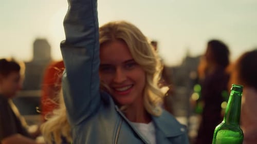 Woman Dancing at Rooftop Party in Golden Light