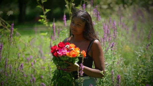 A Woman Holding a Beautiful Bouquet of Colorful Flowers in a Lush and Vibrant Garden