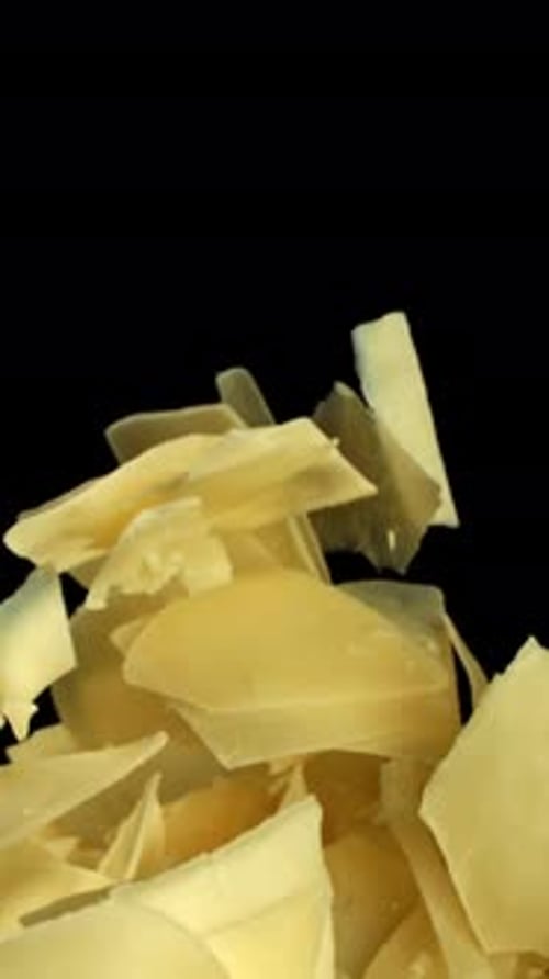 Parmesan Cheese Flakes Fly Upwards on a Black Background Filmed on a Highspeed Camera at 1000 Fps
