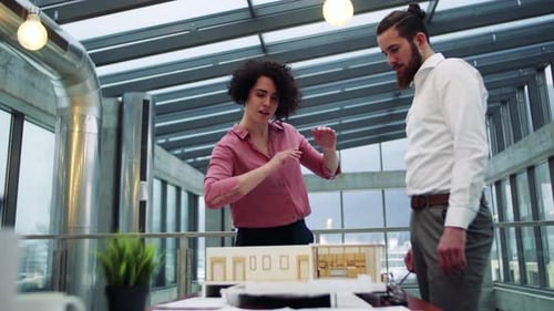 Young architects discussing a new house model in a modern office workplace