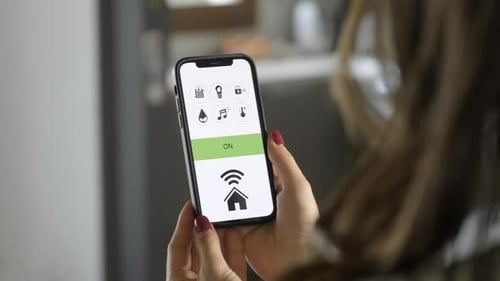 Woman using home automation app on smartphone
