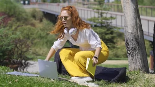 Ein Student, der draußen im Park studiert, ist unglücklich.