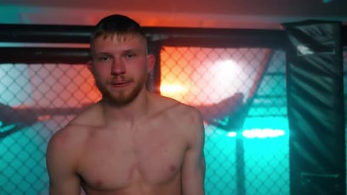 Shirtless Man Standing Inside Fighting Enclosure