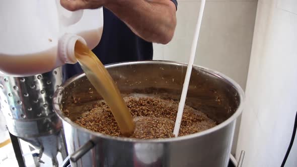High definition shot of man pouring liquid into fermenter to make beer ...