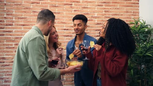 Friends Laughing and Sharing Chips with Drinks