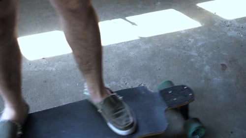 Man rides a board with blue tones highlighted. Waist down.