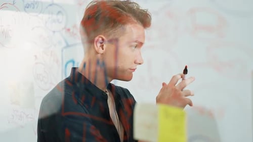 Professional businessman presenting idea on glass white board. Immaculate.