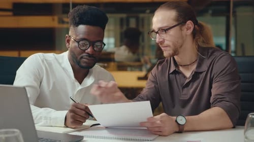Businessmen Discussing Documents at Office Desk