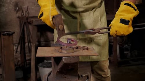 Blacksmith Shaping Hot Metal on Anvil with Hammer