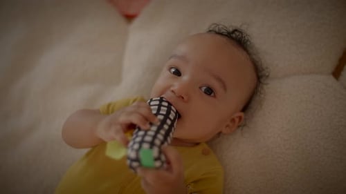 Cute Infant Lying Down Playing with Toy