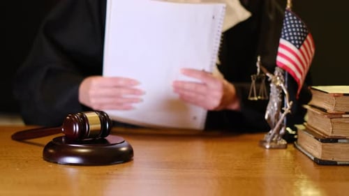 Judge Reviews Legal Documents in Courtroom