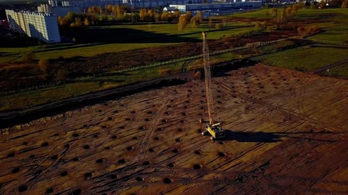 Foto giratoria de un Zumbido aéreo de una grúa de compactación para compactación de tierra ocupada realizando trabajos en tierra a lo largo de
