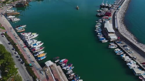 Aerial Video of a Beautiful Port With Small Boats and Elegant White Yachts Docked in a Scenic Blue