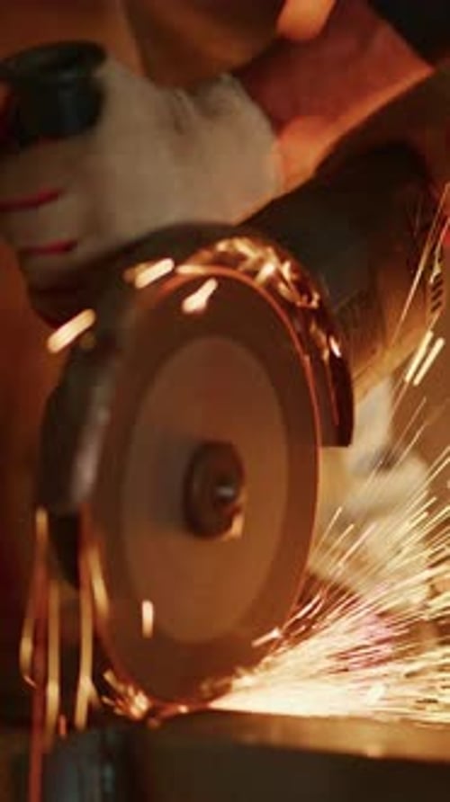 Metal Worker Grinding Metal with Sparks Flying in Workshop