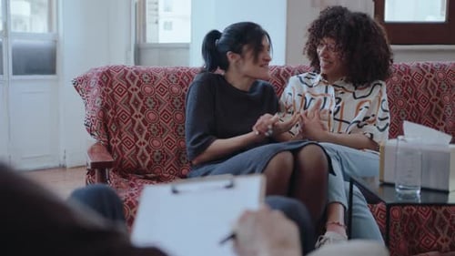 Two Smiling Young Adults Talking in Therapy Session