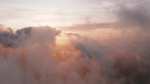Incredible heavenly aerial view flying through light, heaped up and wispy clouds in golden sunset, s