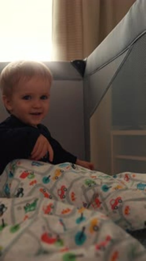 Vertical of Little Boy Crawls on Mattress in Play Tent Looking in Camera