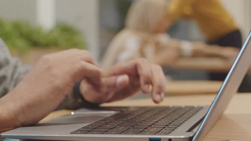 Hands Typing on Laptop Keyboard in Workplace Close Up