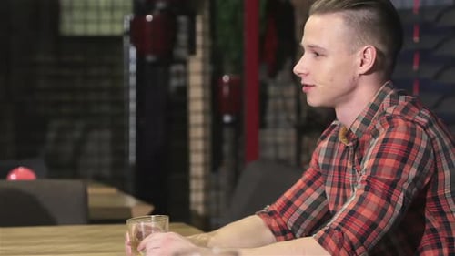 Blonde Man Drinks Alcohol at the Bar