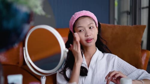 Young Adult Applying Makeup in Mirror