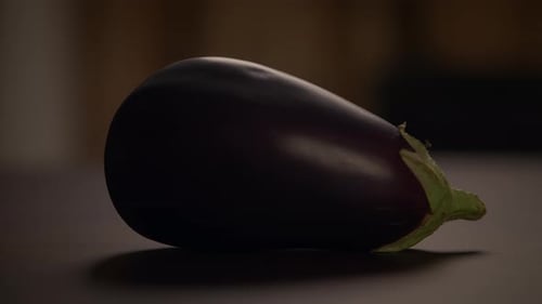 A Fresh Eggplant is Beautifully Displayed on a Table Illuminated By Natural Lighting