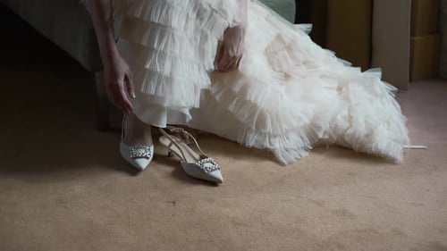 Elegant Woman Puts on Jeweled Heel in Home