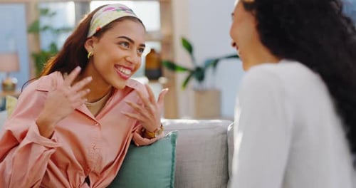 Two Women Talking and Laughing on a Couch