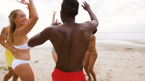 Friends dancing together on sunny beach vacation