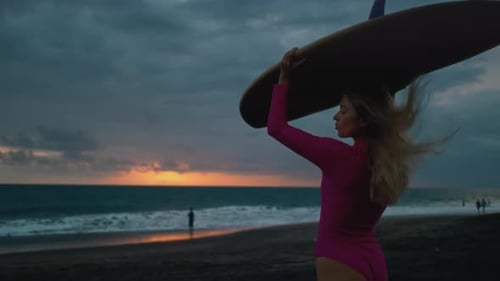 Woman Surfer Walks Along Sand Ocean Beach Holds Surfboard Above Head Girl Walking or Run to Surfing