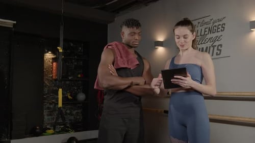 Athletic Man and Woman Discuss Fitness in Gym