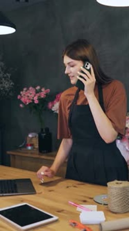 Florist Beautiful Caucasian Woman Girl in an Apron the Owner of a Flower Shop is Talking to a