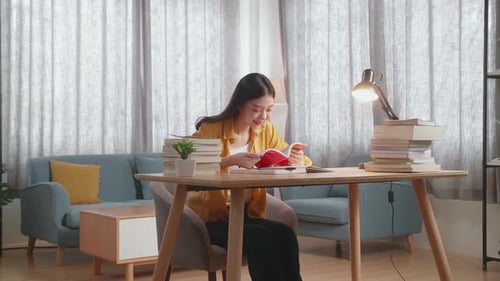 Woman Reading a Book at Desk at Home
