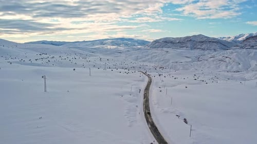 Aerial View of Snow-Covered Mountain Road in Winter Landscape