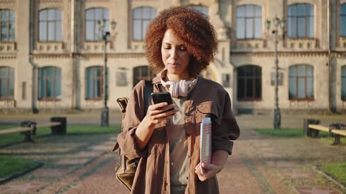Female Student Using Phone on College Campus