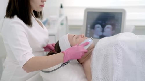 Woman Receiving Modern Facial Treatment in Clinic