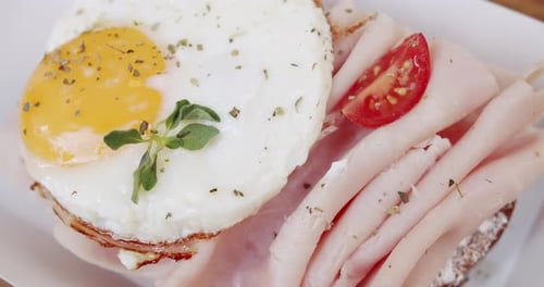 Ham Sandwich Topped With Fried Egg and Tomato