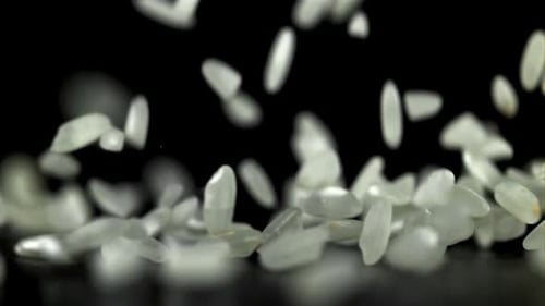 Riz tombant sur fond noir filmé par une caméra haute vitesse à 1000 images par seconde
