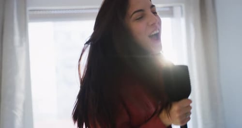 Authentic close up shot of an young happy carefree brunette woman in red shirt is having fun to si